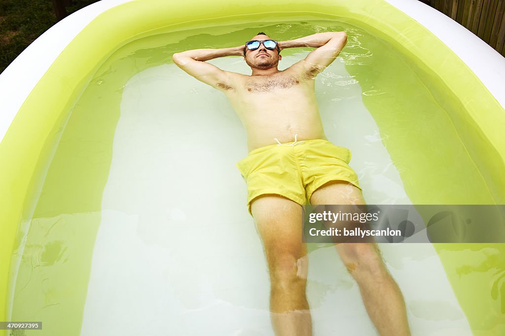 Man relaxing in inflatable pool