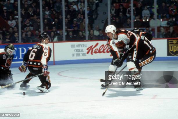Rick Tocchet of the Wales Conference and the Pittsburgh Penguins shoots as Phil Housley of the Campbell Conference and the Winnipeg Jets tries to...