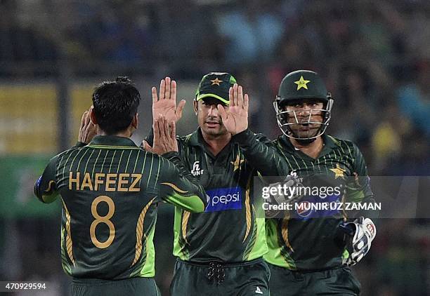 Pakistan cricketer Saeed Ajmal celebrates with teammates after the dismissal Bangladesh cricketer Soumya Sarkar during the T20 match between...