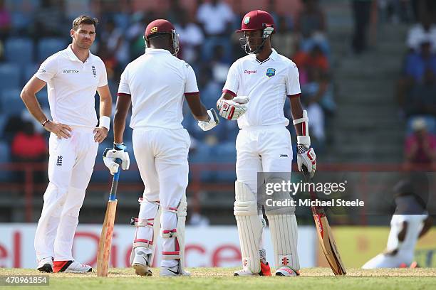 James Anderson of England looks towards Darren Bravo and Kraigg Brathwaite of West Indies as they build a high scoring second wicket partnership...