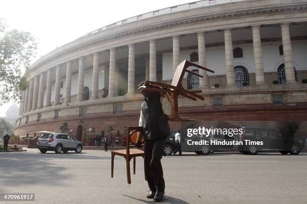 Parliament staff carrying out chairs from Parliament House on the last day of 15th Lok Sabha on February 21, 2014 in New Delhi, India. Rajya Sabha...