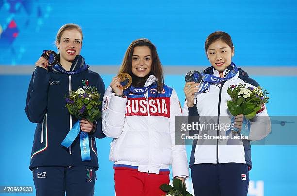 Bronze medalist Carolina Kostner of Italy, Gold medalist Adelina Sotnikova of Russia and Silver medalist Yuna Kim of South Korea celebrate during the...