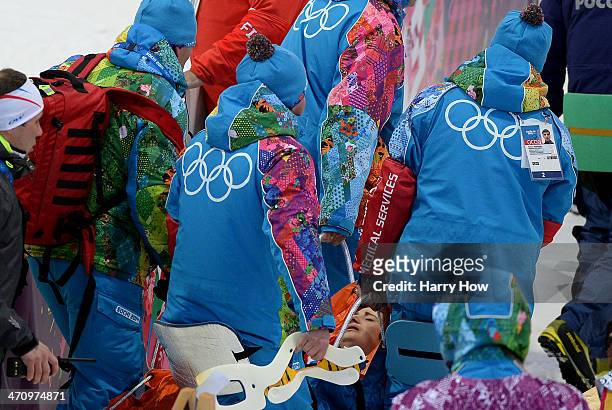 Marie Laure Brunet of France is carried away by course workers and doctors after collapsing in the snow during the Women's 4 x 6 km Relay during day...