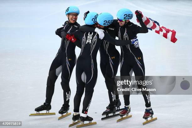 Members of the United States short track team celebrate winning the bronze medal in the Short Track Men's 5000m Relay on day fourteen of the 2014...