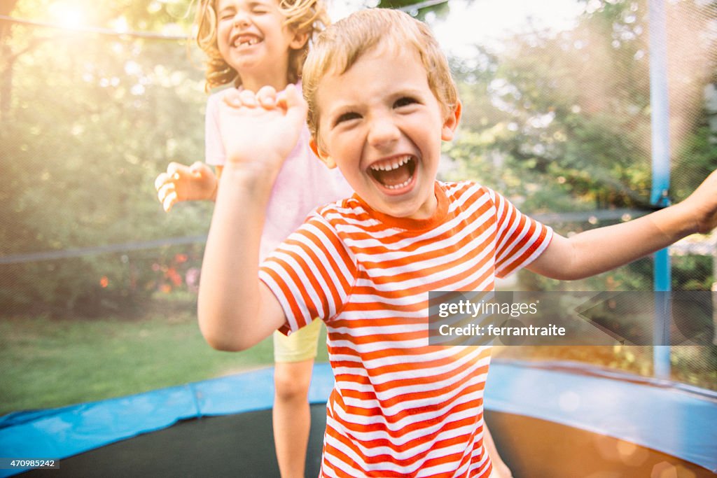 Children on Summer Holidays Jumping on Trampoline