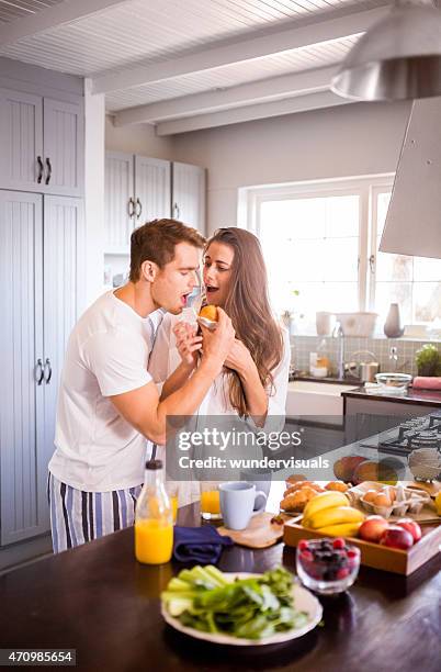 boyfriend stealing his girlfriend's muffin in the morning - man stealing stock pictures, royalty-free photos & images