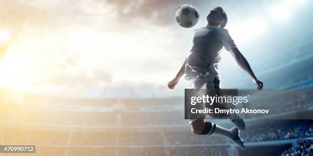 soccer player kicking ball in stadium - football player stock pictures, royalty-free photos & images