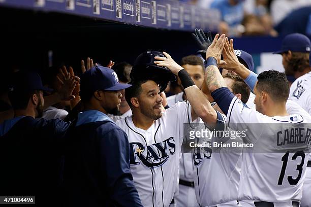 Rene Rivera of the Tampa Bay Rays celebrates with teammates, including Asdrubal Cabrera in the dugout following his two-run home run during the...