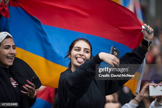 Girls holding an Armenian flag take selfies as members of the Armenian-American community and activists rally near the Turkish Consulate to...