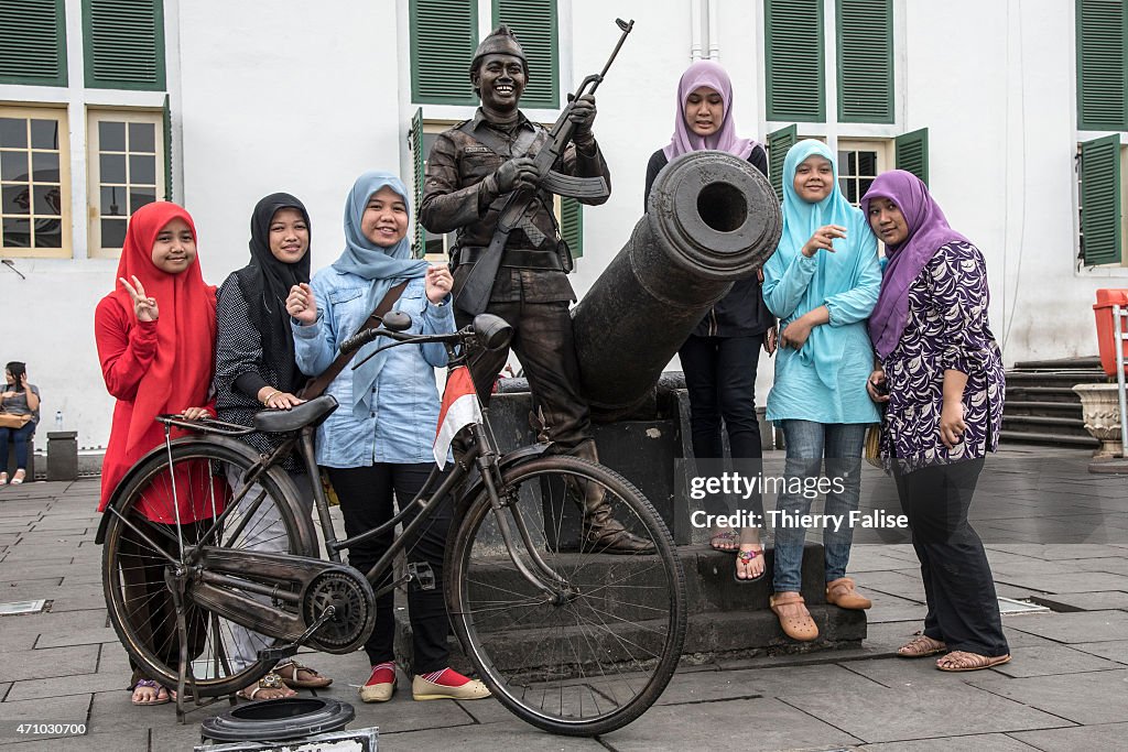 Young Muslim women pause besides an old canon on the...