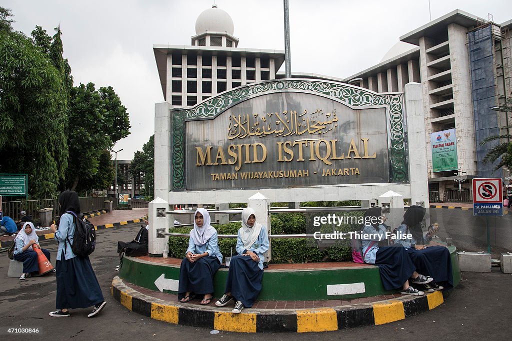 Female students sits at the entrance of the Masjid Istiqlal...