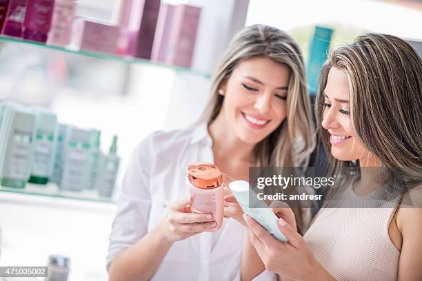 mujeres en una peluquería, comprar productos de belleza - hair products fotografías e imágenes de stock