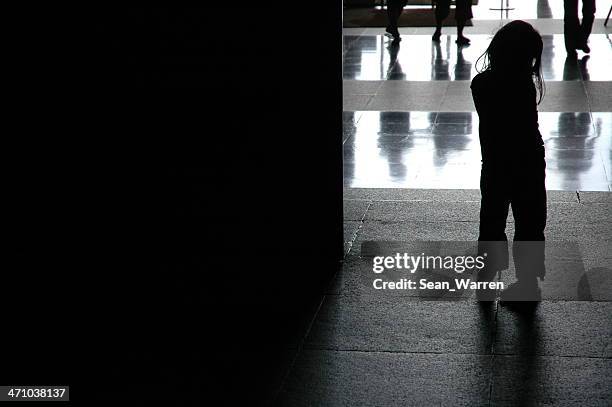 a little girl who seems to be lost in a large public place - verdwaald stockfoto's en -beelden