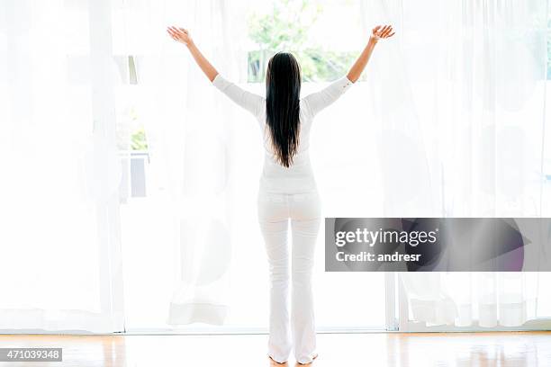 femme ouvrir les fenêtres à la maison - woman fresh air photos et images de collection