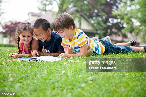 crianças ao ar livre leitura - summer school imagens e fotografias de stock