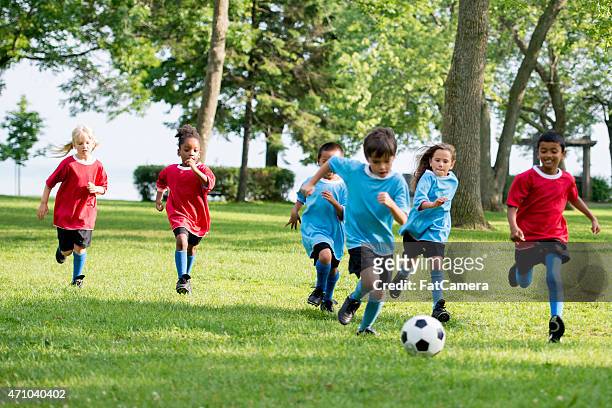 chasing the soccer ball - children only stock pictures, royalty-free photos & images