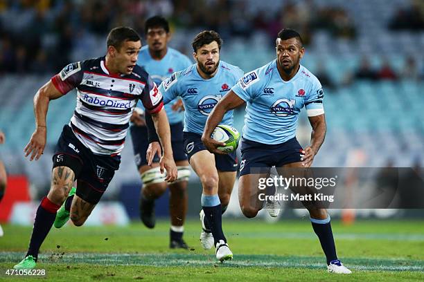 Kurtley Beale of the Waratahs takes on the defence during the round 11 Super Rugby match between the Waratahs and the Rebels at ANZ Stadium on April...