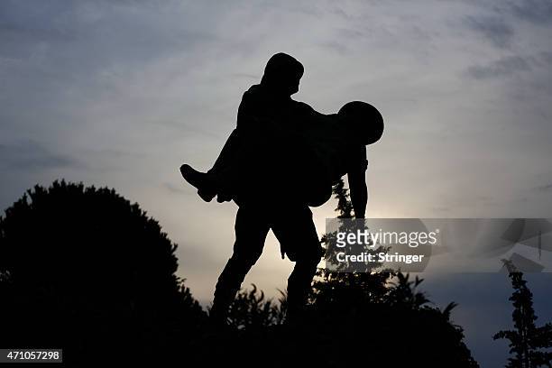 Statue depicting a Turkish soldier carrying an injured Anzac soldier in the bloody Gallipoli campaign in the World War I is silhouetted in Gallipoli...