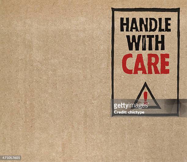 "handle with care" on brown cardboard - fragile stock pictures, royalty-free photos & images