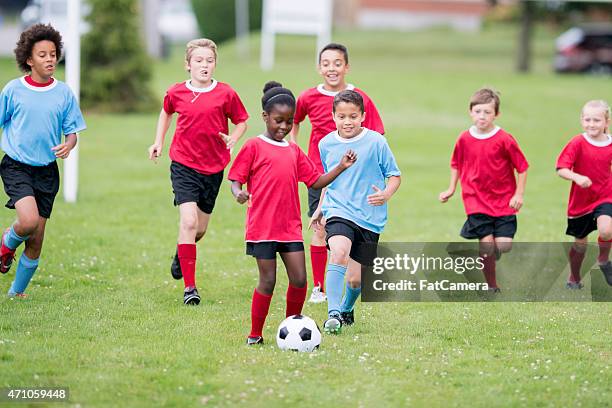 chasing the soccer ball - playing soccer stock pictures, royalty-free photos & images