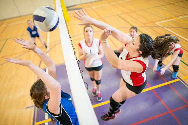 spike and block action shot - girls volleyball stock pictures, royalty-free photos & images
