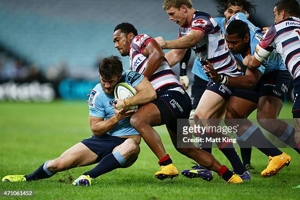 Rob Horne of the Waratahs is tackled during the round 11 Super Rugby match between the Waratahs and the Rebels at ANZ Stadium on April 25, 2015 in...