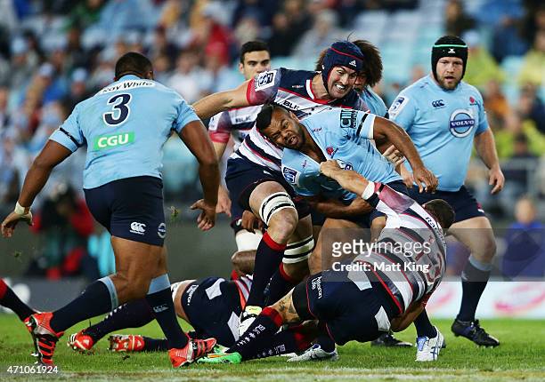 Kurtley Beale of the Waratahs is tackled during the round 11 Super Rugby match between the Waratahs and the Rebels at ANZ Stadium on April 25, 2015...