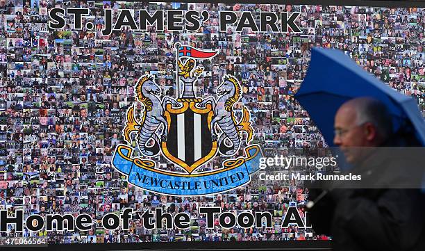 Newcastle united fans hide from the driving rain under umbrellas before the start of the Barclays Premier League match between Newcastle United and...