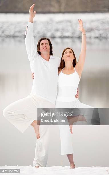 young couple doing yoga in the snow - barefoot snow stock pictures, royalty-free photos & images