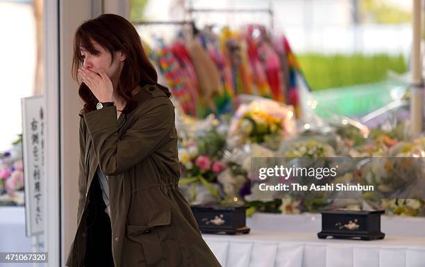 Woman sheds tear after offering a flower at an altar at the accident site of the JR Takarazuka Line on the 10th anniversary of the train derailment...