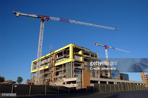 building under construction with two cranes - medical building exterior stock pictures, royalty-free photos & images