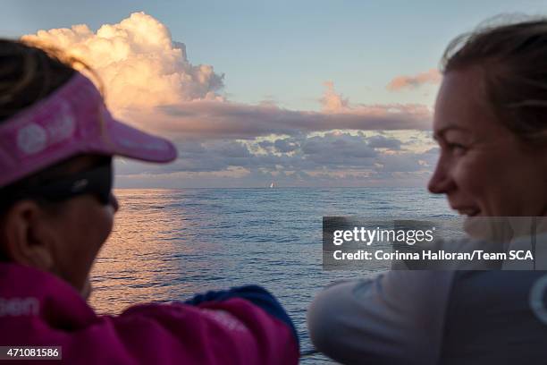 In this handout image provided by the Volvo Ocean Race, onboard Team SCA. Dee Caffari and Sophie Ciszek watch Team Brunel as the sun sets during Leg...