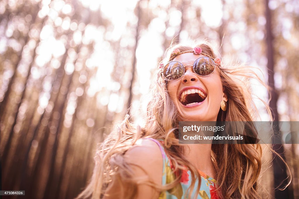 Boho girl laughing in a summer forest