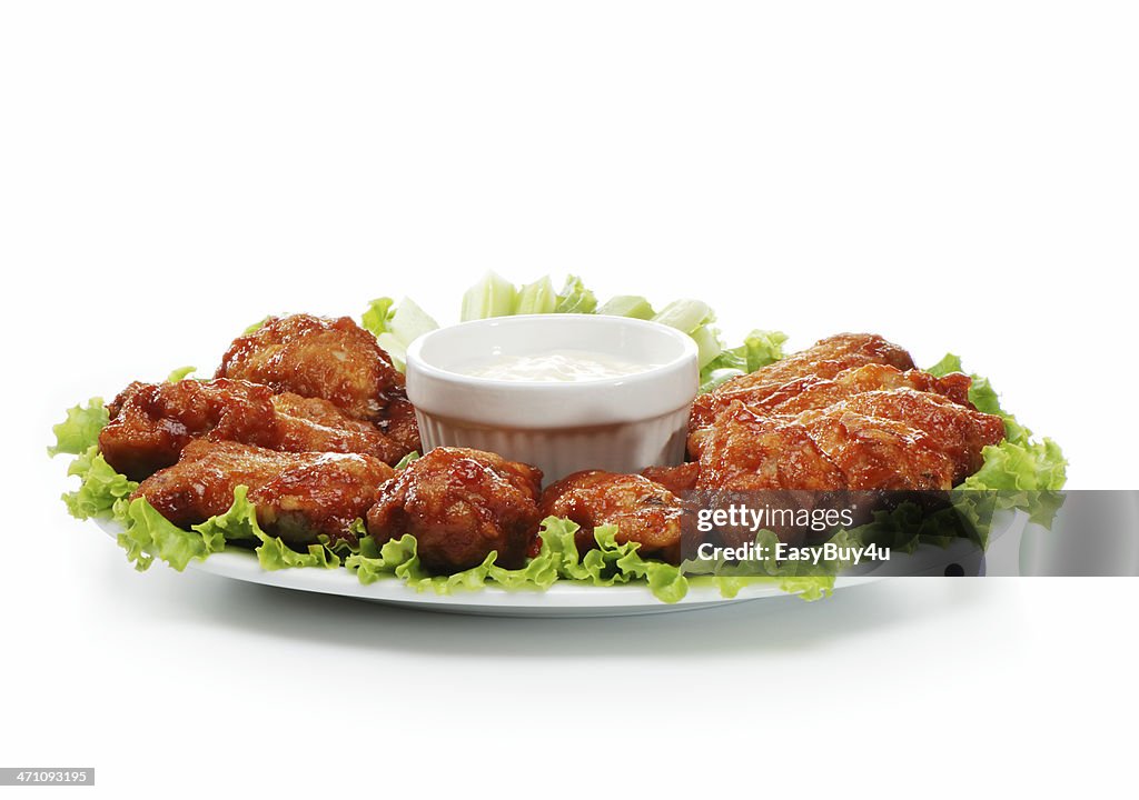 Chicken wings served on a plate with a dip 