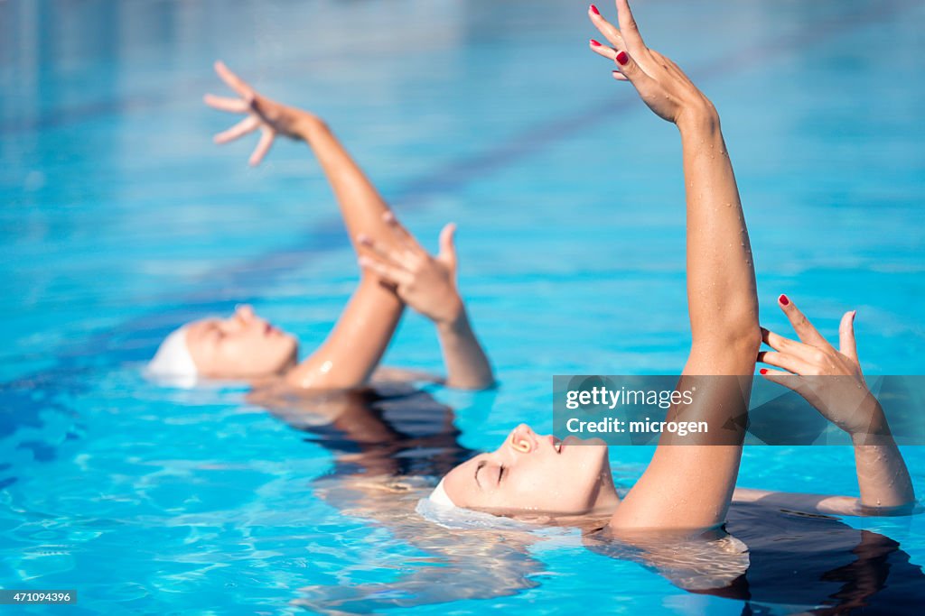 Two female synchronized swimmers