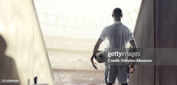 black and white photo of a soccer player walking onto pitch - football pitch bildbanksfoton och bilder