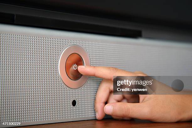 a hand pressing a silver power button on a speaker - turning on or off stock pictures, royalty-free photos & images