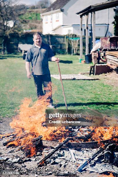 traditional wheelwright heating the metal tyre for a wooden cartwheel - colyton stock pictures, royalty-free photos & images