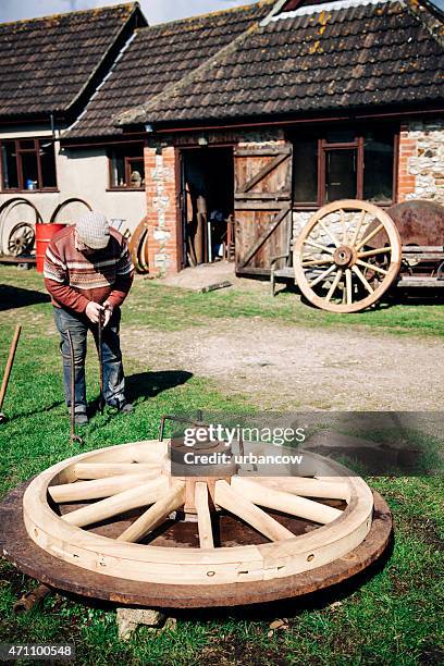 cartwheel on a clamp, skilled wheelwright outside his workshop - colyton stockfoto's en -beelden