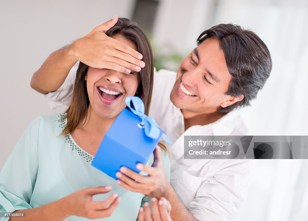 Man surprising his girlfriend with a present