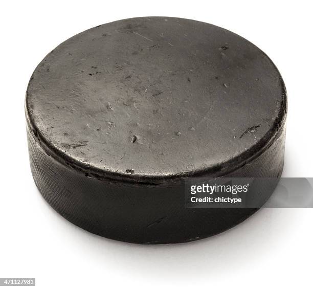 worn black hockey puck on white background - hockey puck stock pictures, royalty-free photos & images