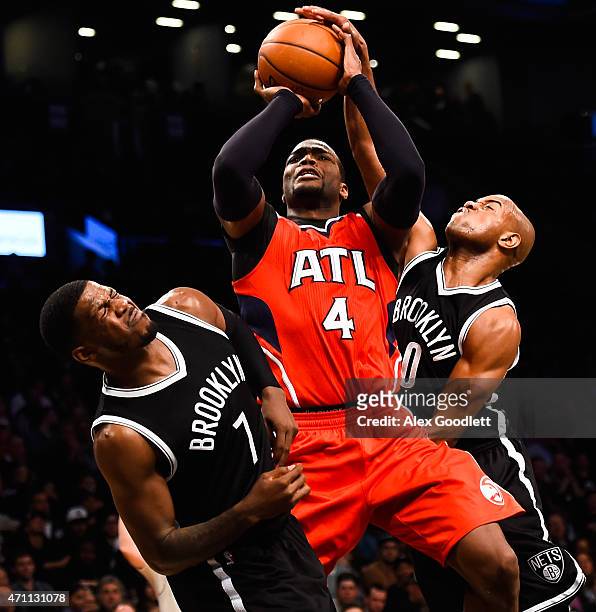Paul Millsap of the Atlanta Hawks attempts a shot over Jarrett Jack and Joe Johnson of the Brooklyn Nets during the first round of the 2015 NBA...