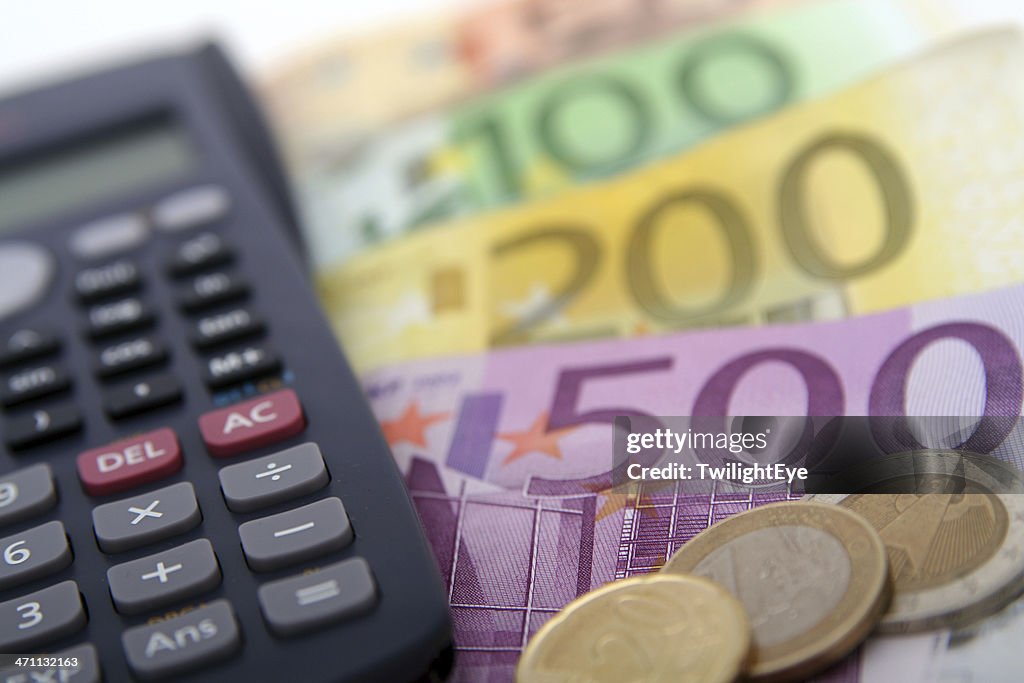 Close-up of a calculator and foreign paper money and coin