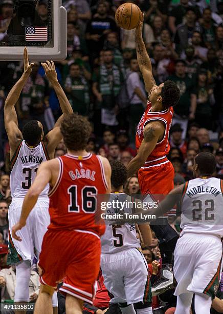 Guard Derrick Rose of the Chicago Bulls shoots over center John Henson of the Milwaukee Bucks in the first quarter of game four of the first round of...