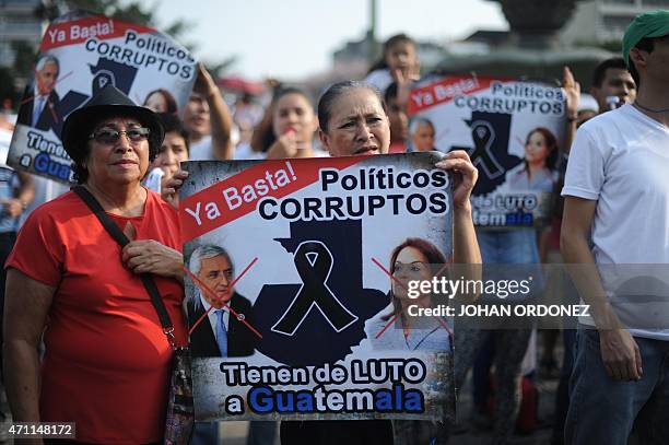 Demonstrators hold signs during a protest against Guatemalan President Otto Perez Molina and Vice President Roxana Baldetti for the recent corruption...