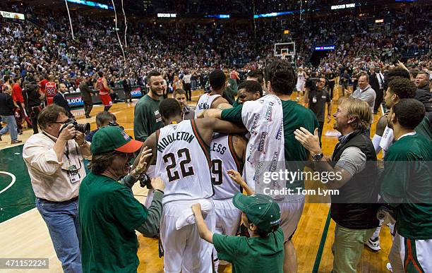 Jerryd Bayless, center with head band, of the Milwaukee Bucks is swarmed by teammates Khris Middleton, left, and Zaza Pachulia, right, after he hit...