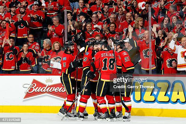 Matt Stajan, David Jones and teammates of the Calgary Flames celebrate a goal against the Vancouver Canucks at Scotiabank Saddledome for Game Six of...