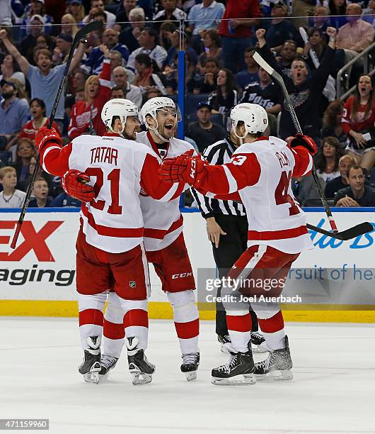 Pavel Datsyuk is congratulated by Tomas Tatar and Darren Helm of the Detroit Red Wings after scoring a goal against the Tampa Bay Lightning during...
