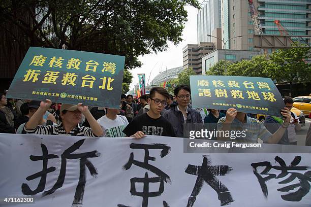 Protesters with signs and banners march down a city street. Civic groups mobilized supporters and called for the Far Glory Taipei Dome to be...