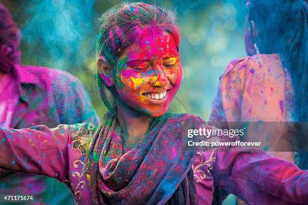 jeune femme profitant de holi festival - colors of india photos et images de collection